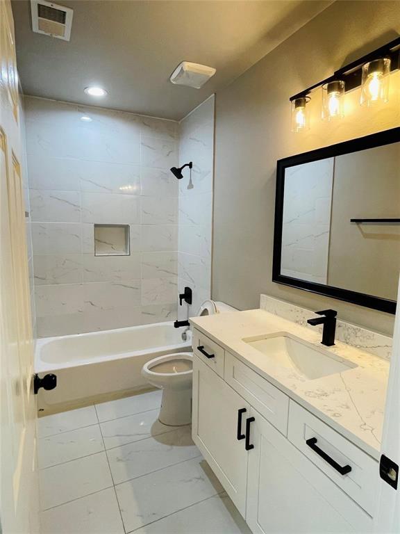 4609 Virginia Avenue, Unit 202 Dallas, TX 75204 - Photo 11 of 21 a bathroom with a granite countertop sink a toilet a mirror and bathtub