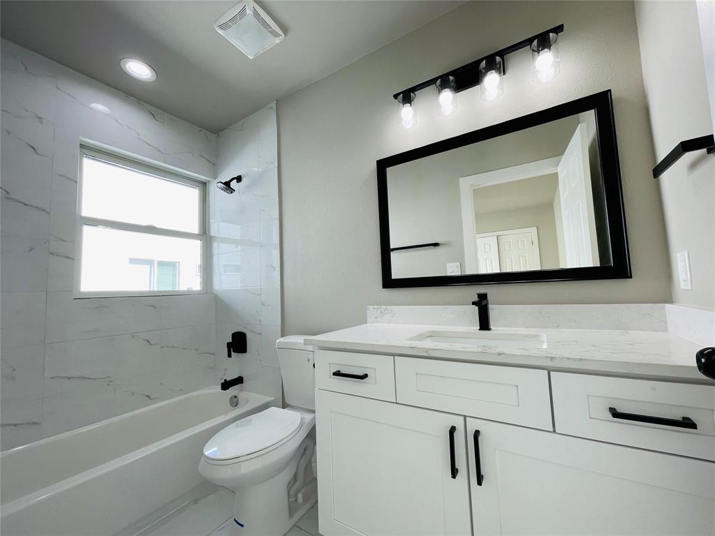4609 Virginia Avenue, Unit 202 Dallas, TX 75204 - Photo 13 of 21 a bathroom with a toilet sink vanity tub and mirror
