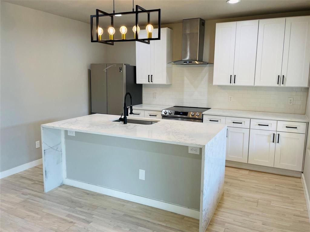 4609 Virginia Avenue, Unit 202 Dallas, TX 75204 - Photo 8 of 21 a kitchen with stainless steel appliances a stove a sink and white cabinets