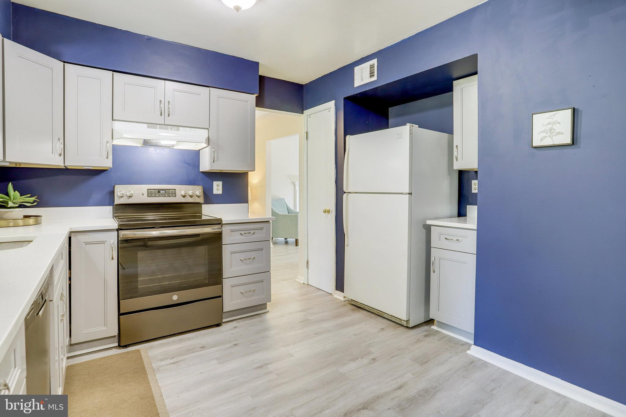 6903 Cherryfield Road Fort Washington, MD 20744 - Photo 16 of 58 a kitchen with a refrigerator stove and white cabinets