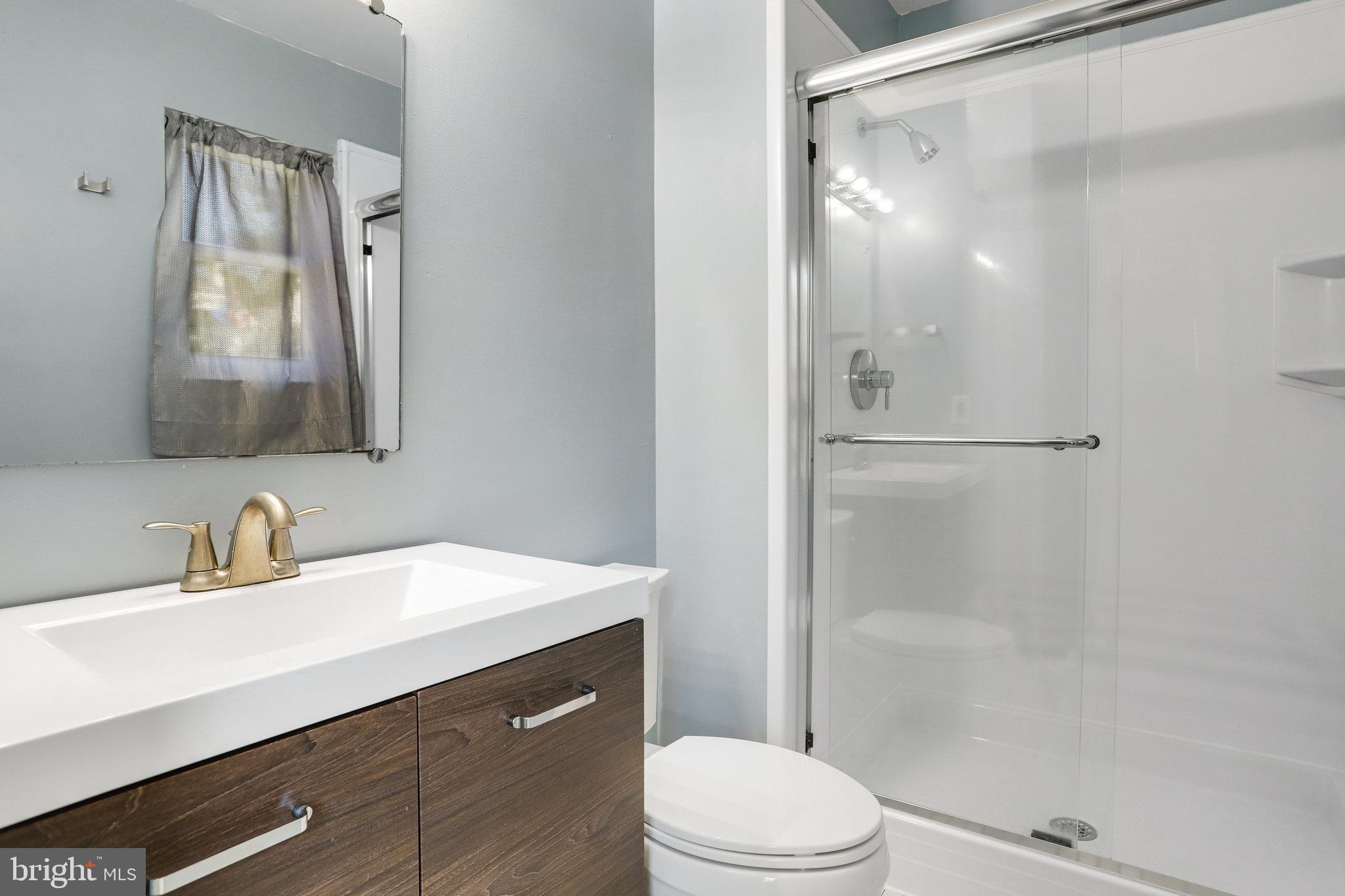 6903 Cherryfield Road Fort Washington, MD 20744 - Photo 39 of 58 a bathroom with a sink a toilet a mirror and shower