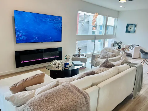 a living room with furniture a fireplace and a large window