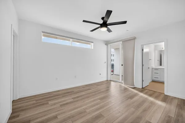 a view of a big room with wooden floor and windows