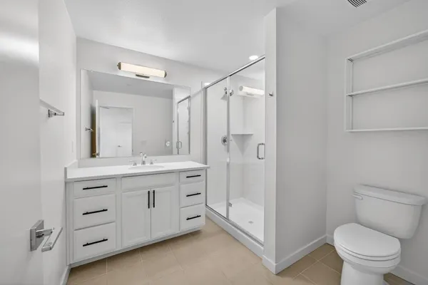a bathroom with a double vanity sink toilet and shower