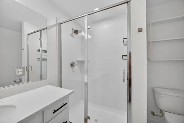 a bathroom with a granite countertop sink toilet and shower