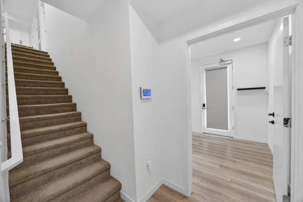 a view of a hallway with wooden floor and entryway