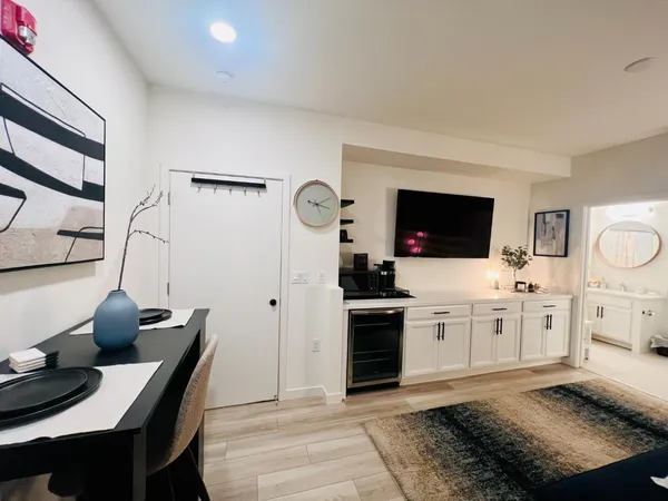 a living room with stainless steel appliances kitchen island granite countertop a sink and a stove top oven
