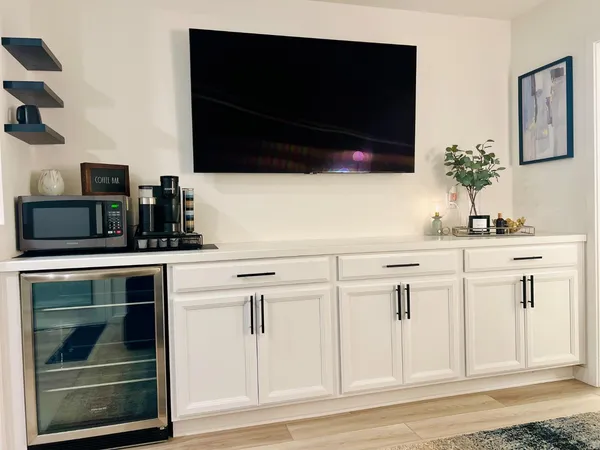 a kitchen with white cabinets and black appliances