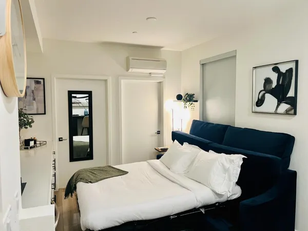 a bedroom with a bed and a painting on the wall