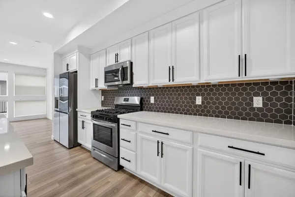 a kitchen with stainless steel appliances granite countertop a refrigerator sink and cabinets