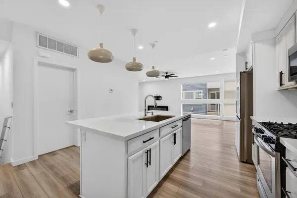a kitchen with a stove and a wooden floor