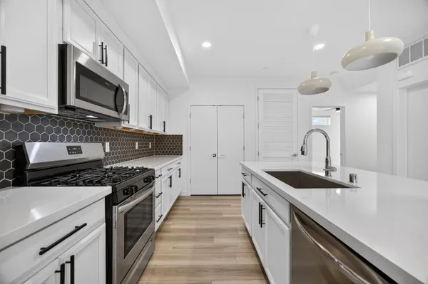 a kitchen with stainless steel appliances granite countertop a sink and stove top oven