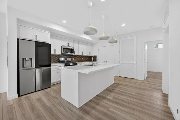 a kitchen with stainless steel appliances a refrigerator and a stove top oven