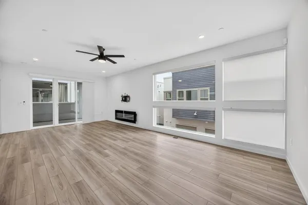 a view of an empty room with a window and wooden floor