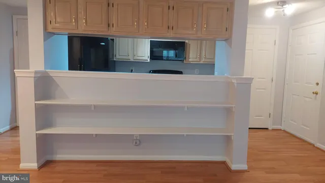 a view of an empty room with wooden floor and a cabinet
