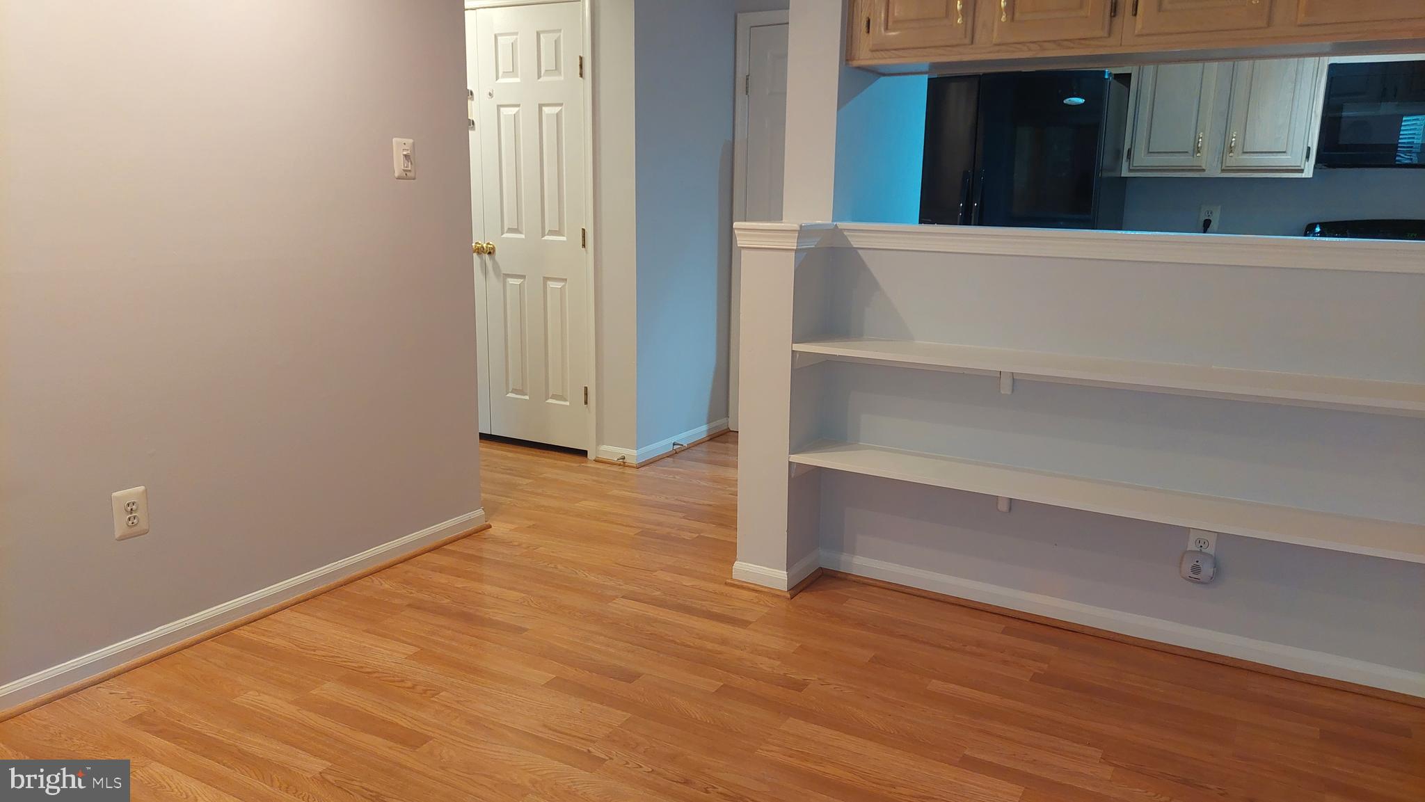 13107 Briarcliff Terrace, Unit 2203 Germantown, MD 20874 - Photo 14 of 53 a view of an empty room with wooden floor and a cabinet
