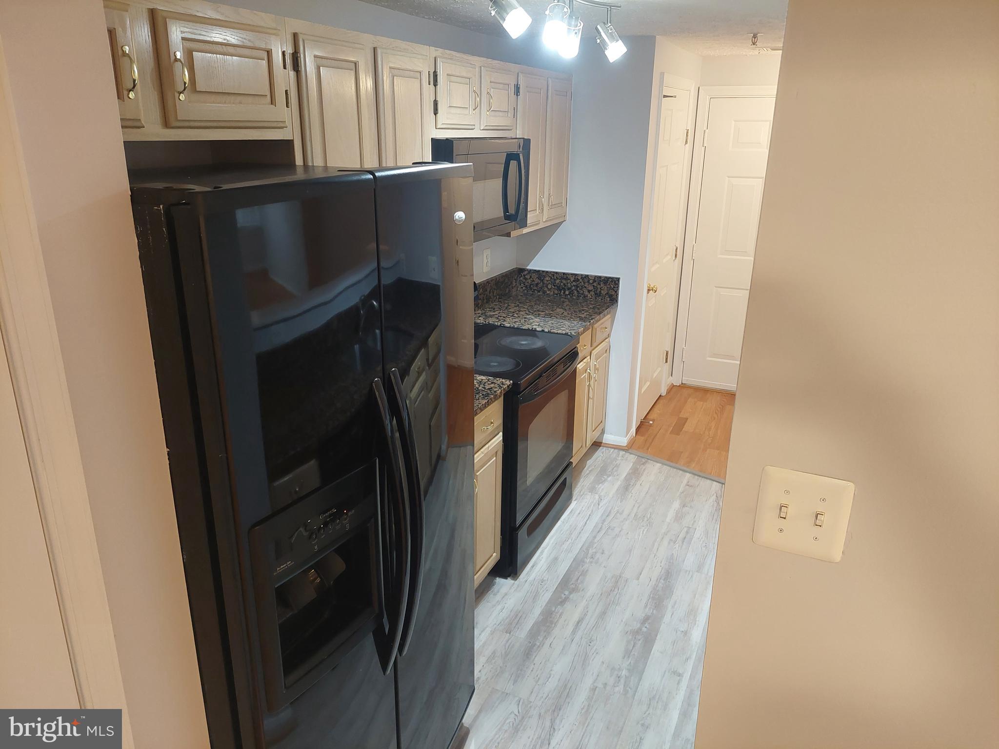 13107 Briarcliff Terrace, Unit 2203 Germantown, MD 20874 - Photo 23 of 53 a kitchen with stainless steel appliances granite countertop a refrigerator a stove and a sink with wooden floor