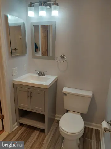 an empty room with wooden floor cabinet and windows