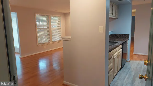 a kitchen with granite countertop a sink a stove and wooden floor