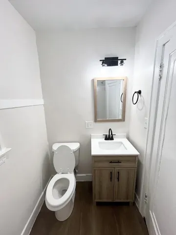 a bathroom with a toilet sink and mirror