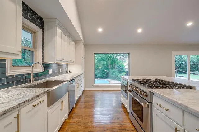 a kitchen with stainless steel appliances granite countertop a sink stove and cabinets
