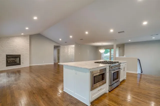 a kitchen with a stove and a wooden floors