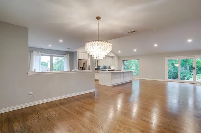 a view of a kitchen with granite countertop wooden floor and a chandelier