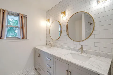 a bathroom with a double vanity sink and a mirror