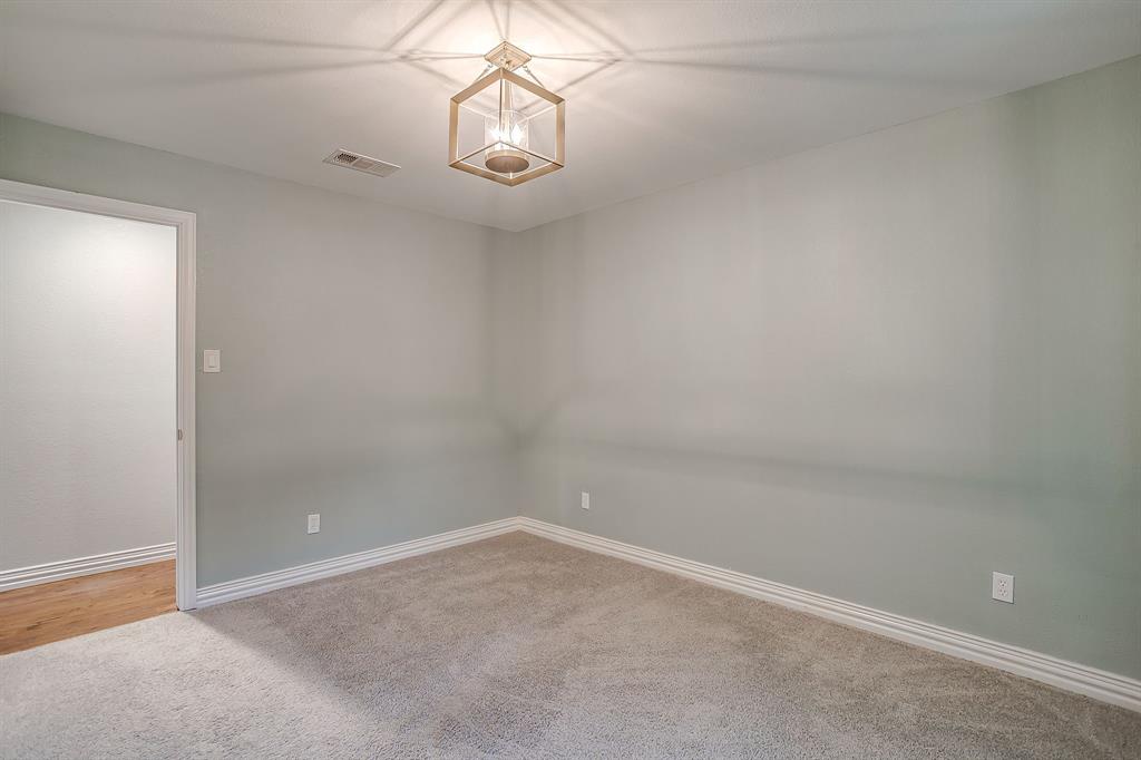 6336 Inca Road Fort Worth, TX 76116 - Photo 23 of 39 en empty room with a chandelier fan and windows