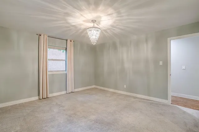 an empty room with closet and a chandelier fan