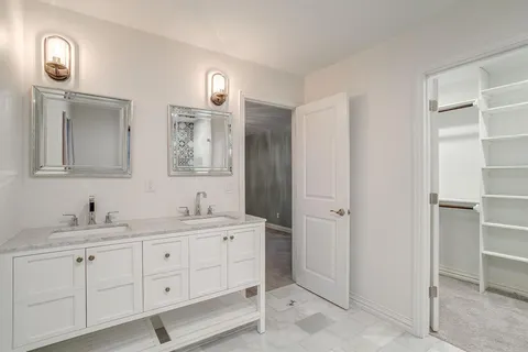 a bathroom with a double vanity sink and a mirror