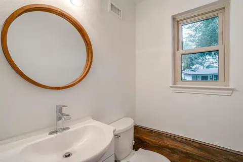 a bathroom with a sink a mirror and a toilet
