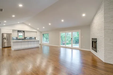a view of an empty room with a kitchen counter top and a fireplace