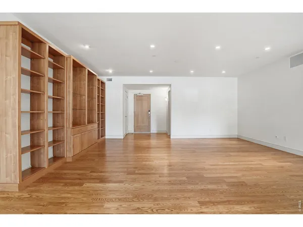 a view of an empty room with wooden floor