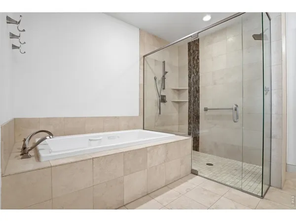 a bathroom with a tub a sink a mirror and a shower