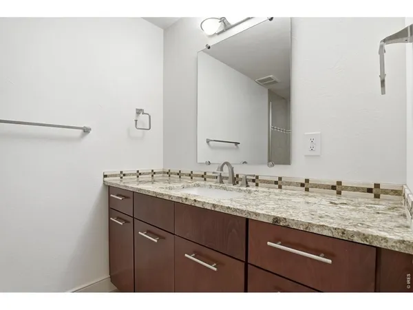a bathroom with a granite countertop shower mirror and a sink