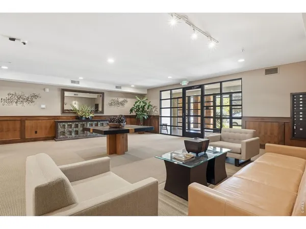 a living room with furniture kitchen view and a large window