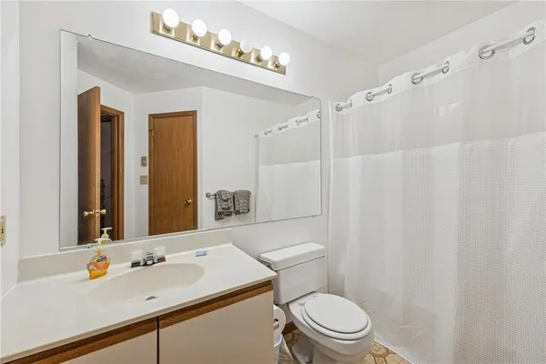 a bathroom with a sink vanity mirror and toilet