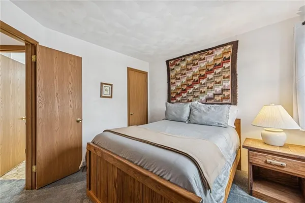 a bedroom with a bed and a painting on the wall