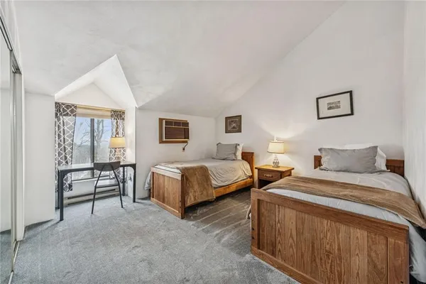 a bedroom with two beds and painting on the wall