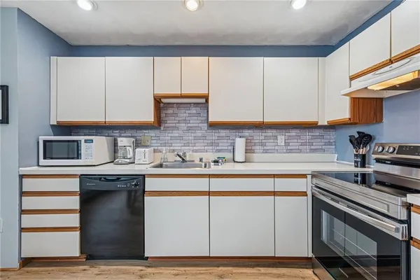 a kitchen with cabinets appliances and a sink