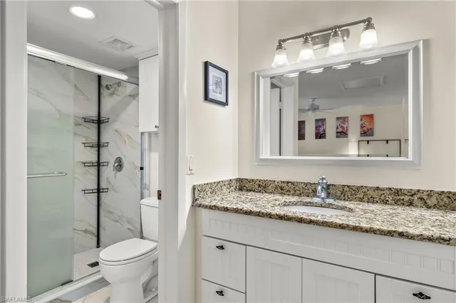 a bathroom with a granite countertop sink toilet and shower