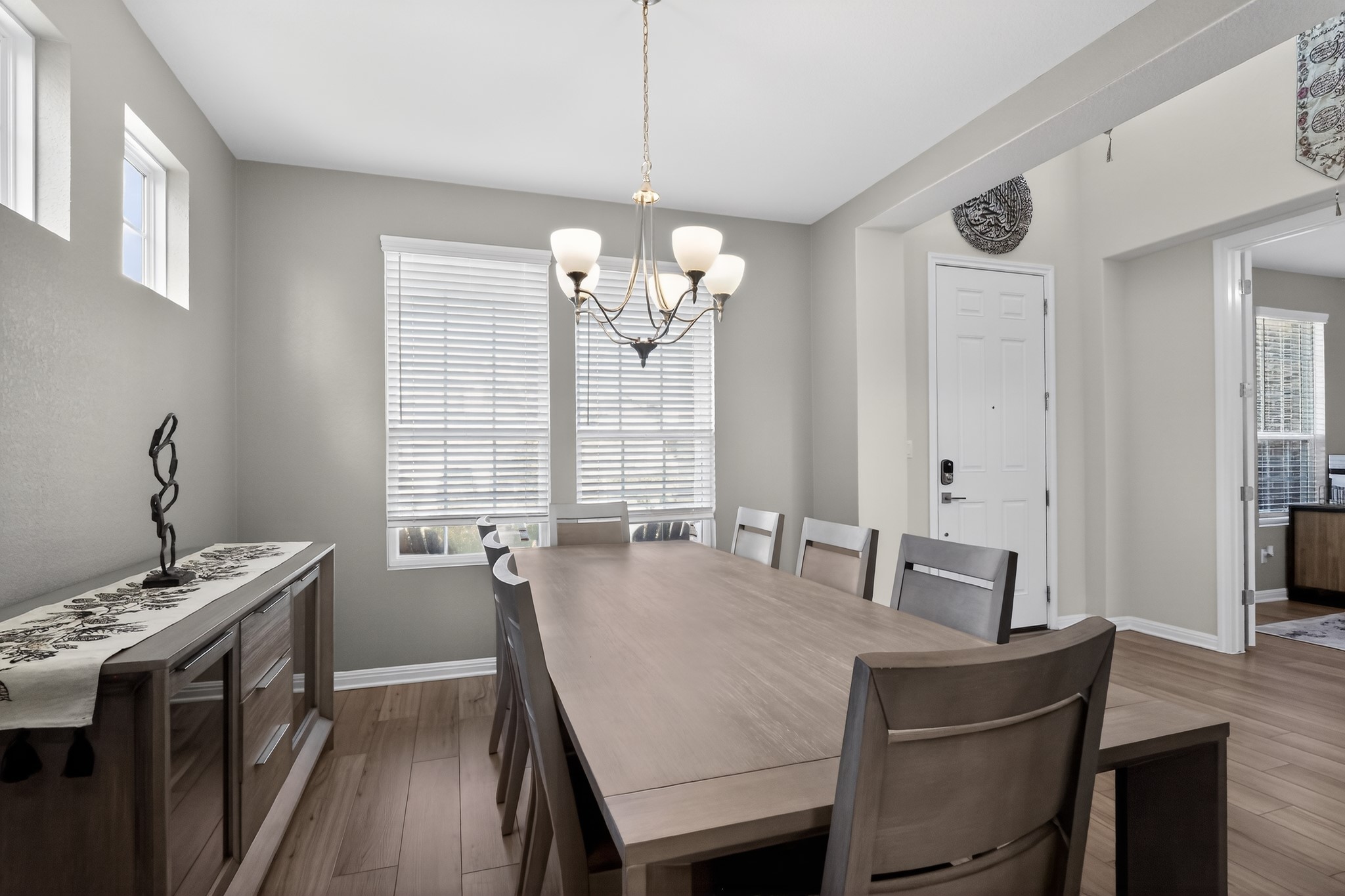 114 Bosco Road Hutto, TX 78634 - Photo 6 of 39 A refined dining space features wood flooring and bright natural light through multiple windows, perfect for memorable gatherings.