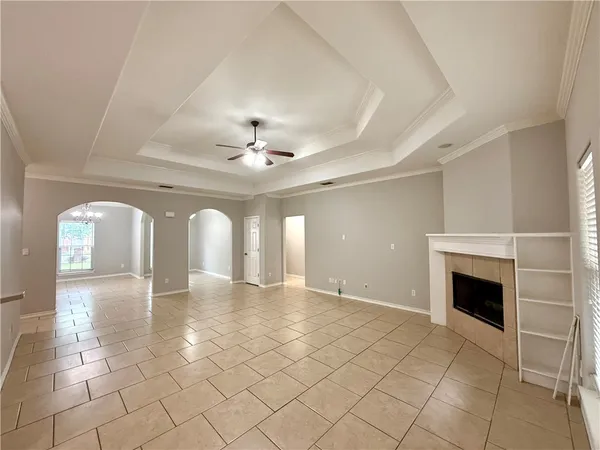 an empty room with windows and fireplace