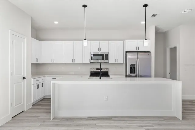 a view of a kitchen with cabinets and stainless steel appliances