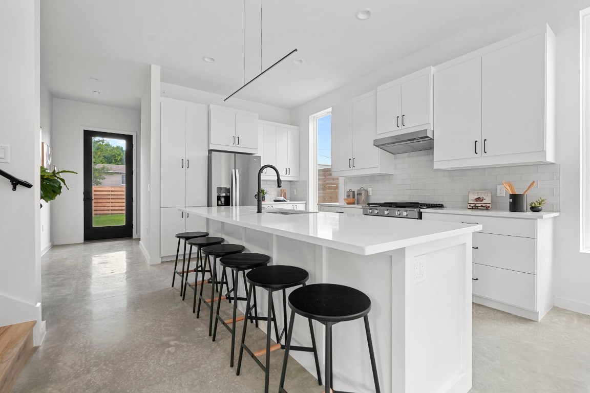 5001 Rob-Scott Street, Unit 1 Austin, TX 78721 - Photo 1 of 1 a kitchen with stainless steel appliances a dining table chairs refrigerator and sink