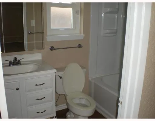 a bathroom with a toilet sink vanity and mirror