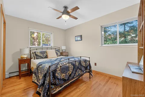 a bedroom with a bed a window and a wooden floor