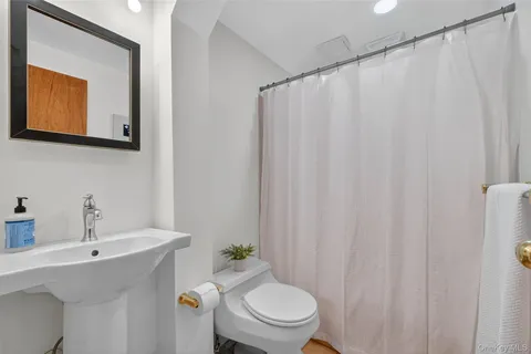 a bathroom with a toilet a sink and a mirror