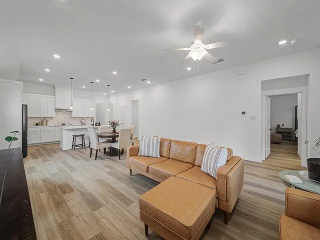 a living room with furniture and kitchen view